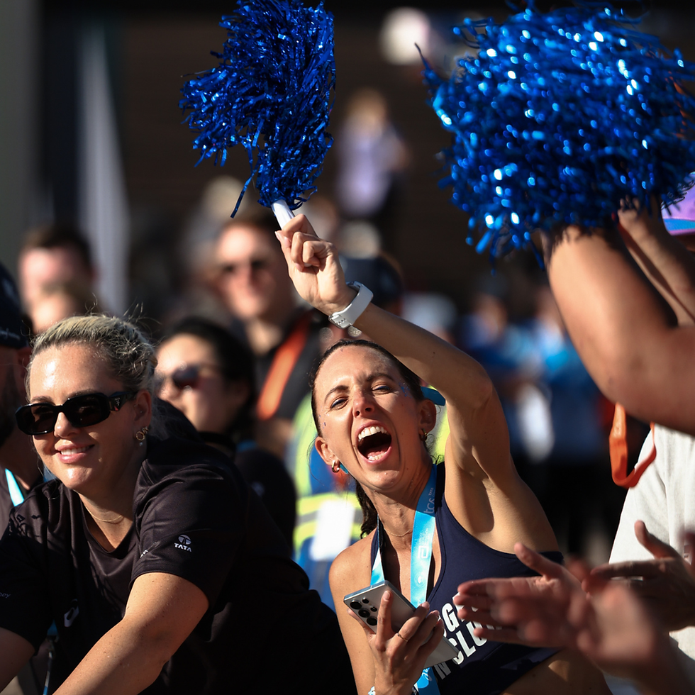 Woman cheering with blue pom-poms in a crowd