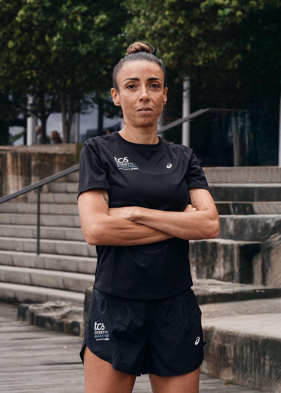 Female runner in TCS Sydney Marathon gear posing outdoors.