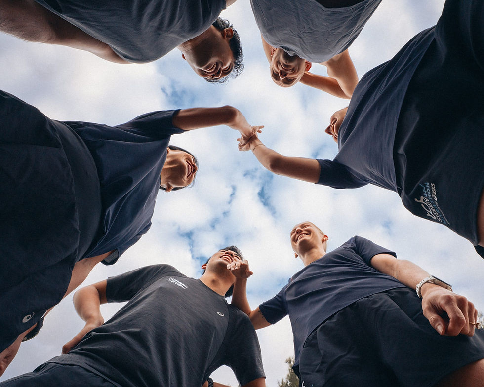 Runners in a huddle against a cloudy sky