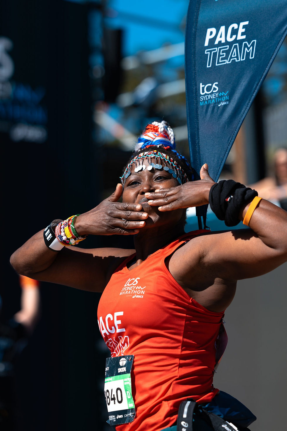Runner blowing a kiss with Pace Team flag at TCS London Marathon